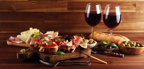 Italian antipasti wine snacks set. Cheese variety, Mediterranean olives, Prosciutto di Parma, tomatoes, artichokes