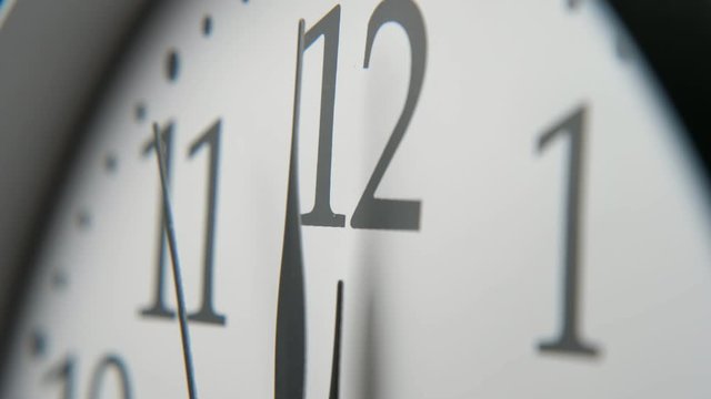 Old-fashioned white clock face put aslant showing a fast-moving second hand 