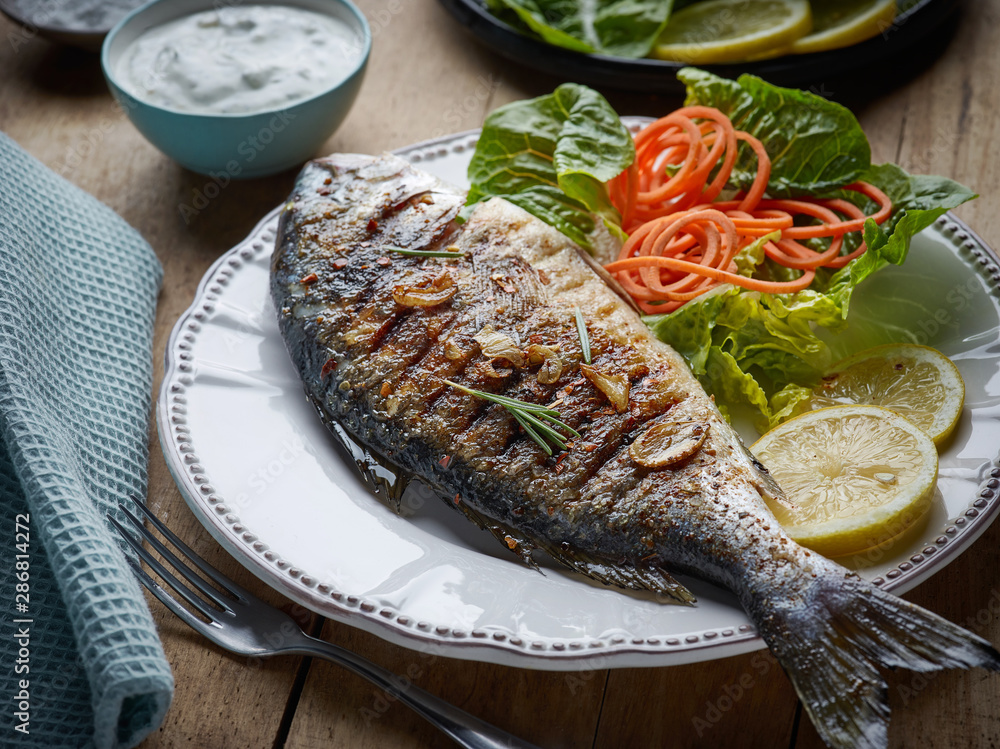 Sticker grilled fish on wooden kitchen table