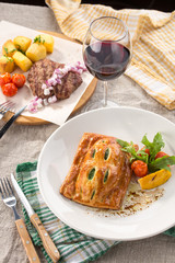 lunch set Puff pastry bun with spinach and grilled beef steak and glass of red wine on the table