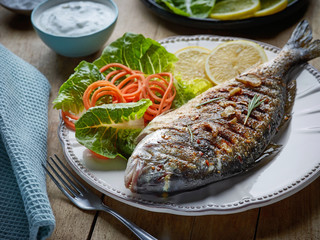 grilled fish on wooden kitchen table