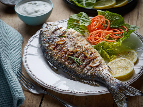 grilled fish on wooden kitchen table