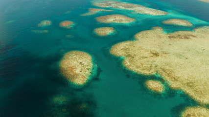 Sea water surface in lagoon with coral reef copy space for text, aerial view. Top view transparent turquoise ocean water surface. background texture