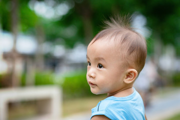 Portrait of little adorable Asian baby boy in park