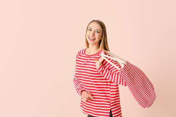 Obraz premium Beautiful young woman with bag on color background
