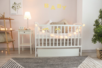 Stylish baby bed in interior of children's room