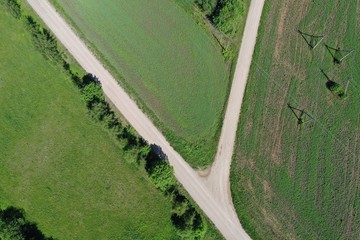Aerial view of gravel road on farm fields in spring