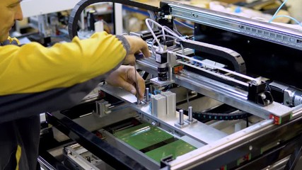 engineer removing nozzle from machine at surface mount Technology, SMT for maintenance and clearing, place to electronic equipment, blur background