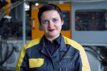 Portrait Of Female Engineer Operating CNC Machinery In Factory