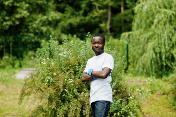 Naklejka na ściany i meble African volunteer man in park. Africa volunteering, charity, people and ecology concept.