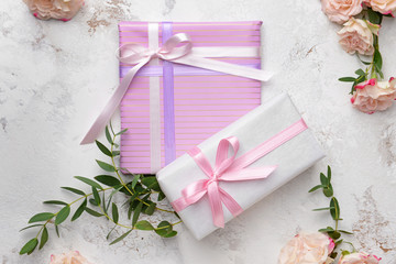 Gift boxes and beautiful flowers on light background