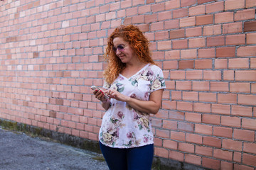 woman using mobile phone with brick wall background