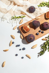 Figs, pear and blueberries on a cutting wooden board.