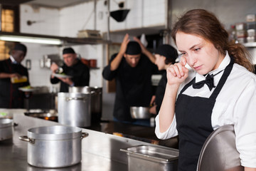 Tired and upset waitress in kitchen of restaurant