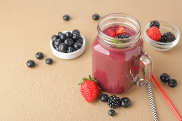 Mason jar of acai smoothie on color background