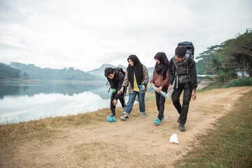 group of hikers picking up trash while camping