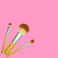 eco friendly makeup brushes with wooden handle isolated on pink background. flat lay.