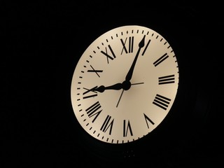 Wall clock with Roman numerals, black background