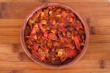 Serving fresh meat in earthenware dish with red  pepper