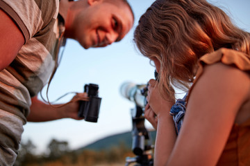 Father and daughter observing the sky with a telescope.