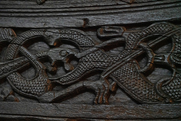 Wooden dark brown ornamental background. Oslo, Norway - part of ancient vessel in the Viking Ship Museum.