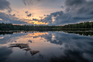 Scenic lake landscape with tranquility mood, sunset and beautiful reflections at summer evening in Finland
