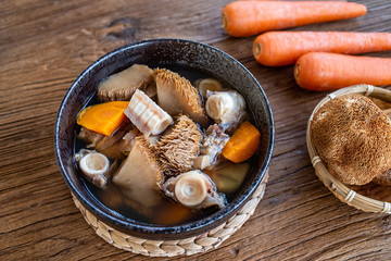 A bowl of Hericium erinaceus shark bone soup on a wooden table © Lili.Q