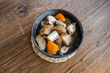 A bowl of Hericium erinaceus shark bone soup on a wooden table © Lili.Q