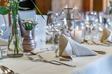 Closeup of decorated wedding tables, with flowers serviette and cutlery