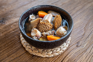 A bowl of Hericium erinaceus shark bone soup on a wooden table