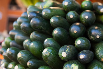 Fresh zucchini on market counter in wicker basket