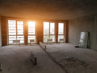 huge space of a new luxury modern apartment with floor-to-ceiling windows in an apartment building under construction