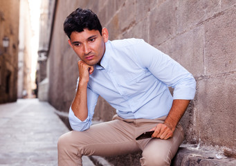 young European guy in blue shirt walking around city