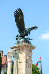 bronze statue of eagle with open wings holding sword in its claws at main gate of Buda fortress in Budapest, Hungary