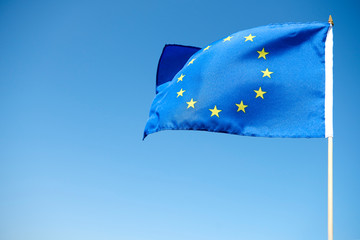 Waving European Union Flag on the blue background