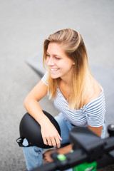 Fototapeta na wymiar Freudig lachende junge Frau mit E-Scooter 