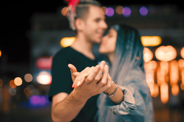 Young couple holding hands at night dancing with love