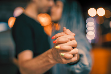 Young couple holding hands at night dancing with love