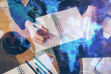 Forex graph on hand taking notes background. Concept of research. Multi exposure