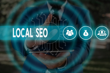 Handwriting text Local Seo. Conceptual photo helps businesses promote products and services to local customers Male human wear formal work suit presenting presentation using smart device