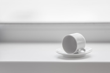 Empty white coffee cup on windowsill