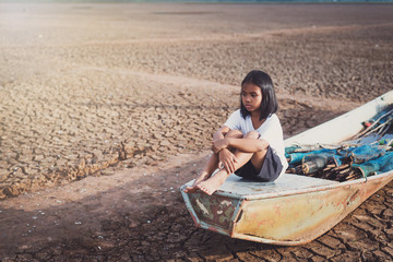 Sad Asian girl sitting on boat suffer from drought , Climate change from global warming.