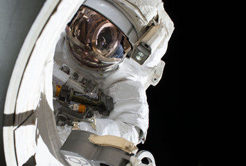 Astronaut in a spacesuit at the space station. Elements of this image were furnished by NASA
