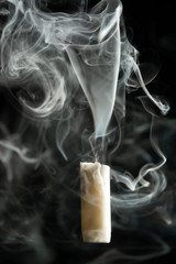 extinguished candle and smoke in the dark
