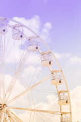 Fototapeta premium Ferris wheel on the colorful cloudy sky. Background concept of happy holidays time.
