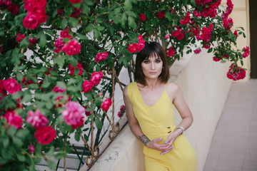 Woman beauty with tattoo on hand near roses in garden.