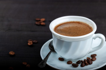 Cup of coffee on a black wooden table