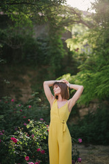 Woman beauty with tattoo on hand near roses in garden.
