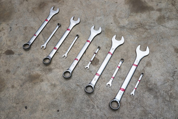 Different wrenches for car repair on a concrete floor.