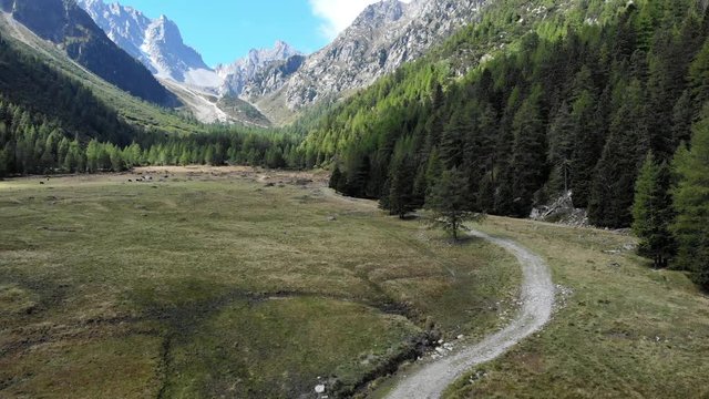 Mountain hiking trail aerial shot. Camera rising to show the scenic panorama in the Swiss alps